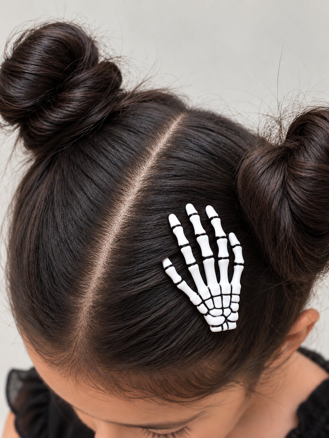 Girl's hair styled with a Skeleton Hand Halloween clip