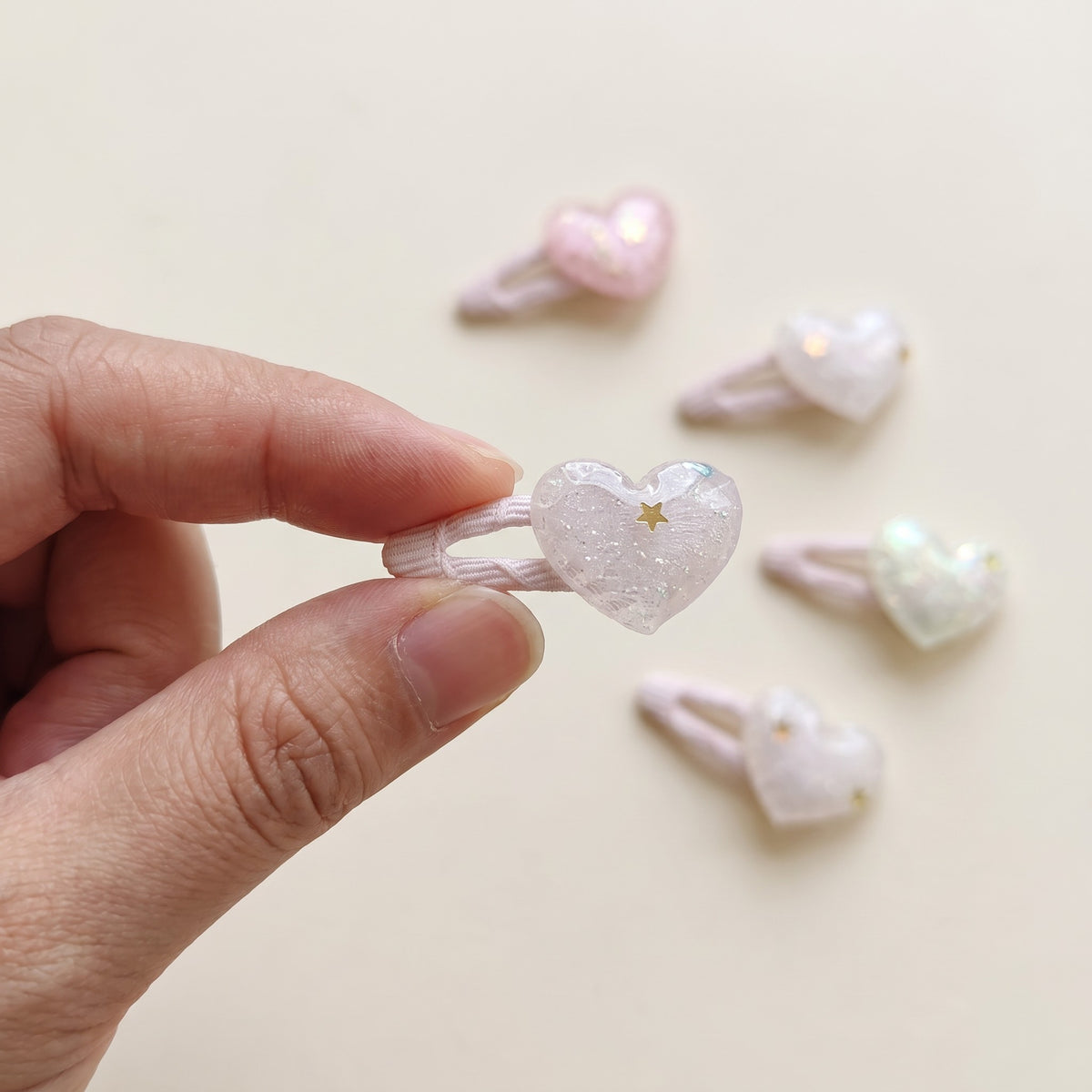 Glitter heart tic tac clip held in hand to show its 4 cm size
