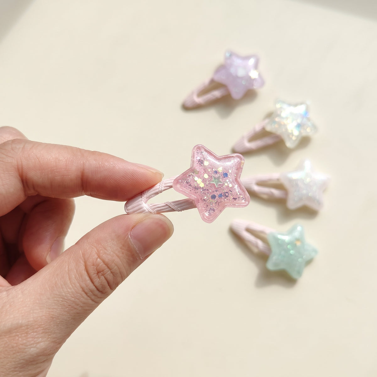 Glitter star tic tac clip held in hand to show its 4 cm size