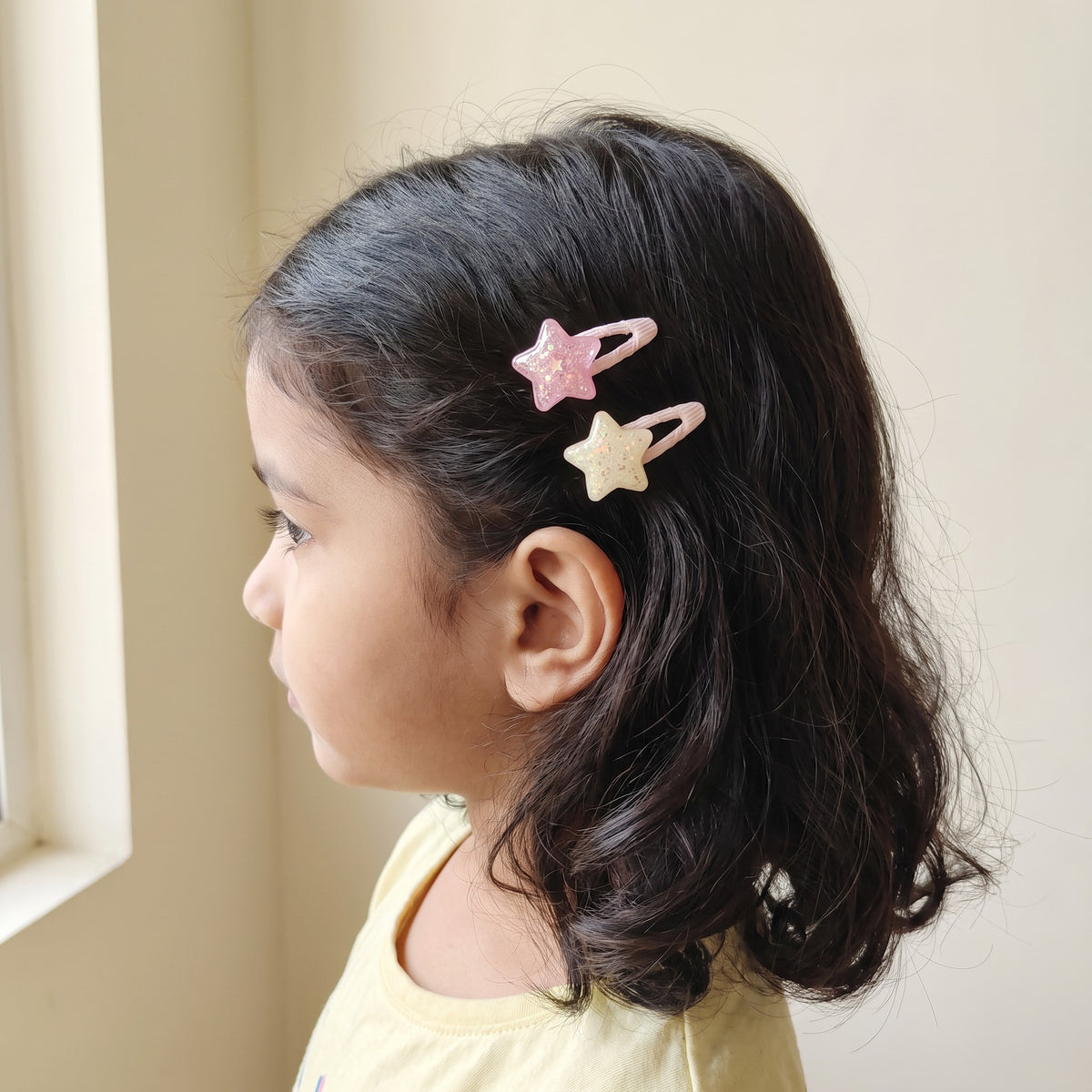 Glitter star tic tac clips worn in a girl's hair