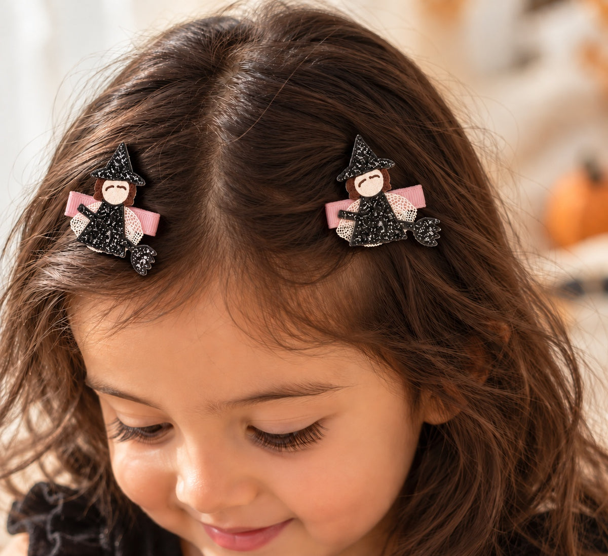 Toddler wearing a pair of Witch on Broomstick Halloween clips