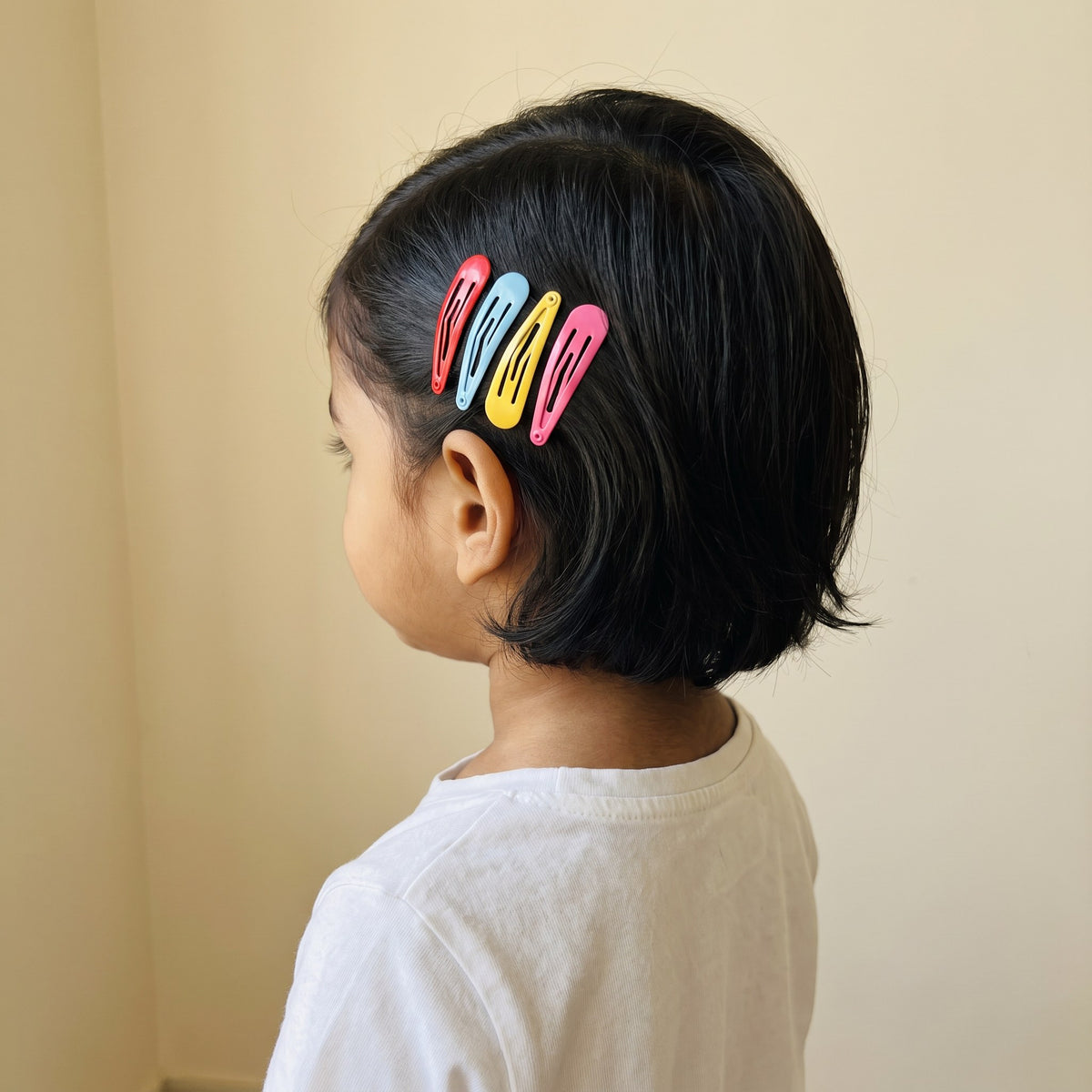 Multicolored tic tac clips worn in a girl's hair