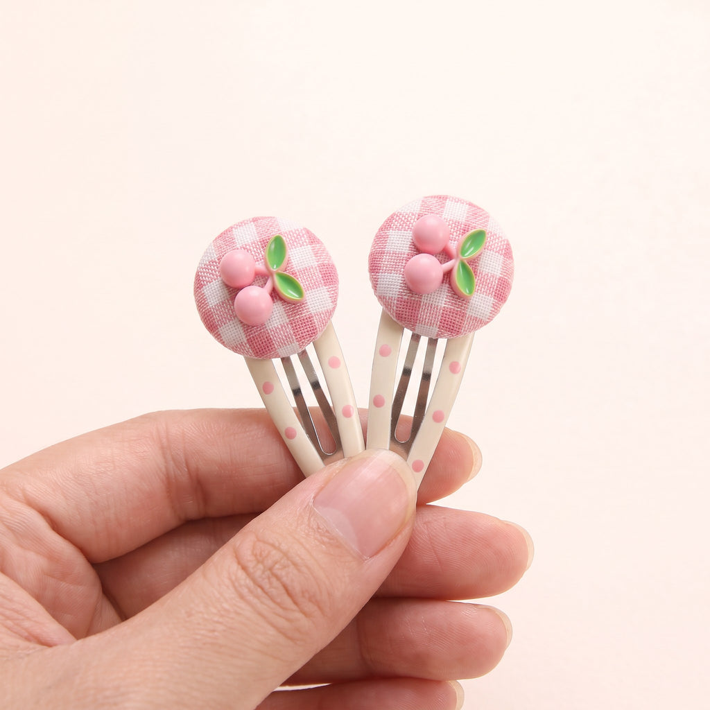 Cherry Gingham Hair Clips held in hand to show size