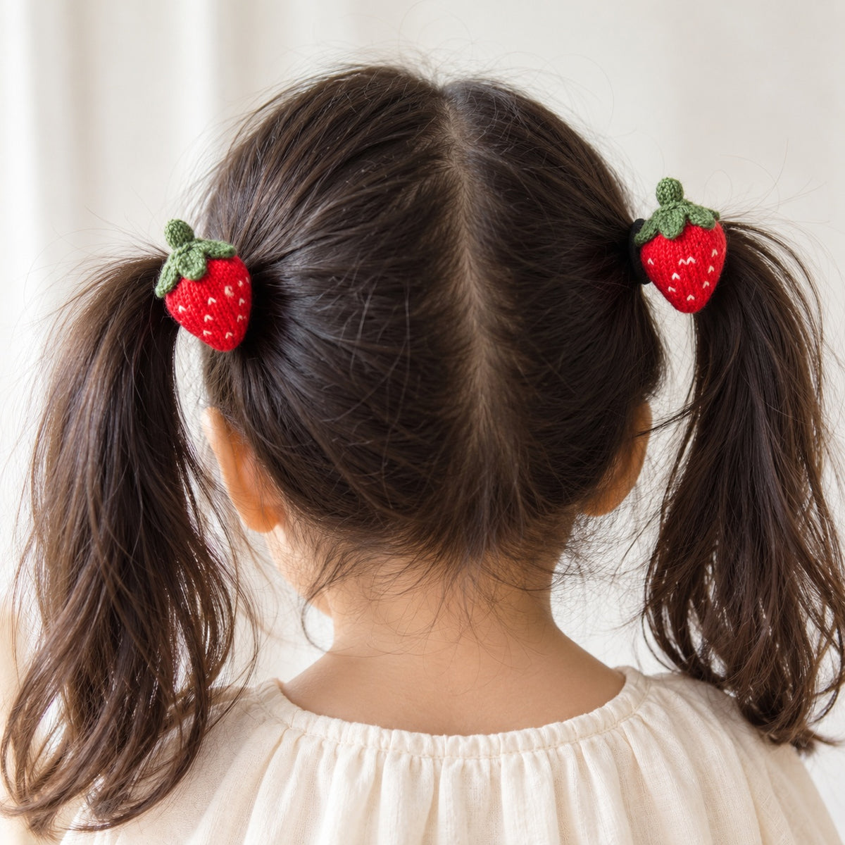 two bobby Knit Strawberry Hair Ties – Pair – red, worn in pigtails