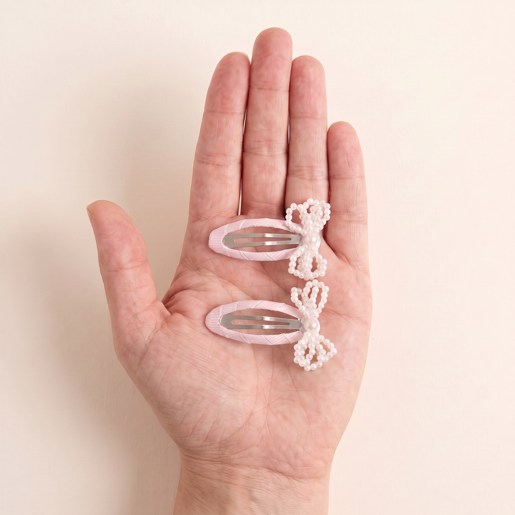 two bobby Mini Pearl Bow Snap Clips - Pink, size in hand