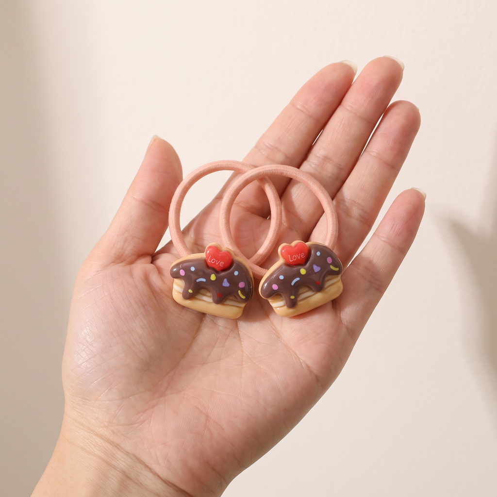 two bobby Sprinkle Cake Hair Ties – One pair in hand, for size