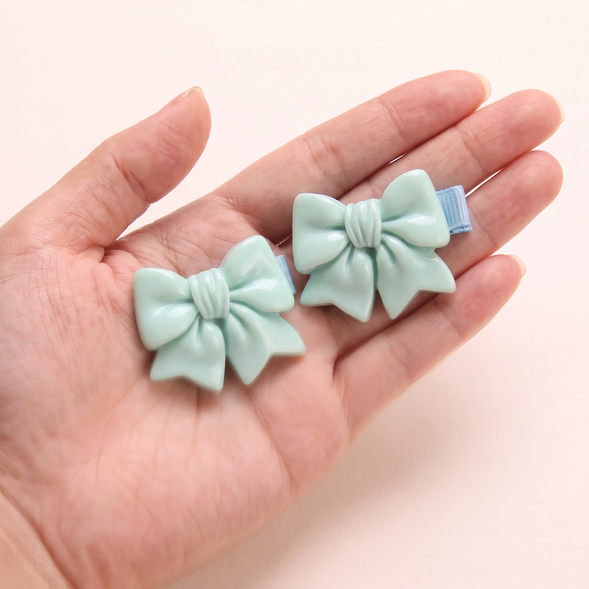 two bobby Glossy Bow Clips – One pair in hand, for size