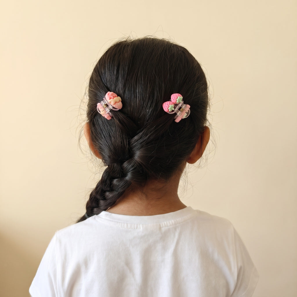 Girl wearing two charm mini claw clips, seen from behind