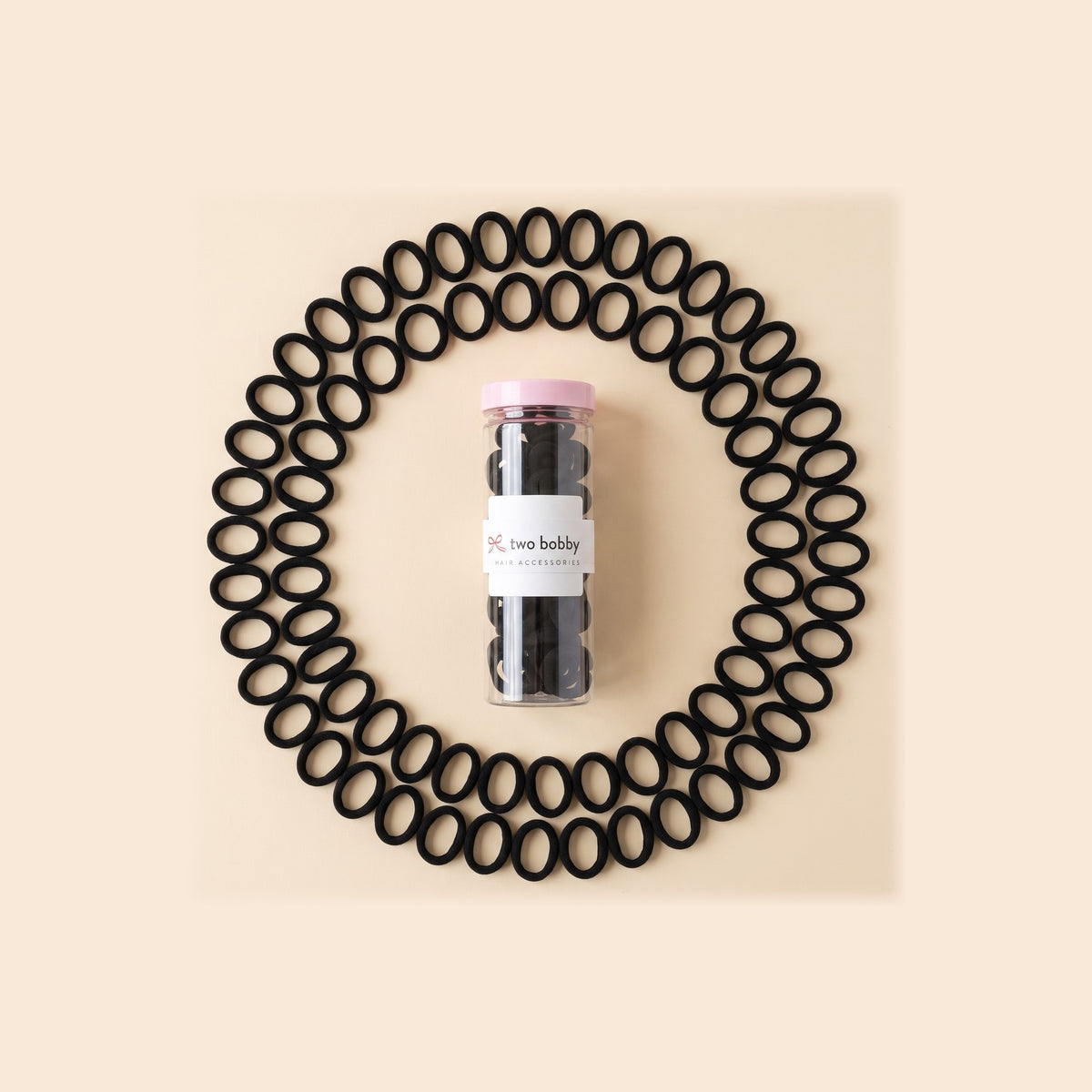 two bobby Everyday Rubber Band Hair Ties - Black, ring of hair ties round the tube of 100
