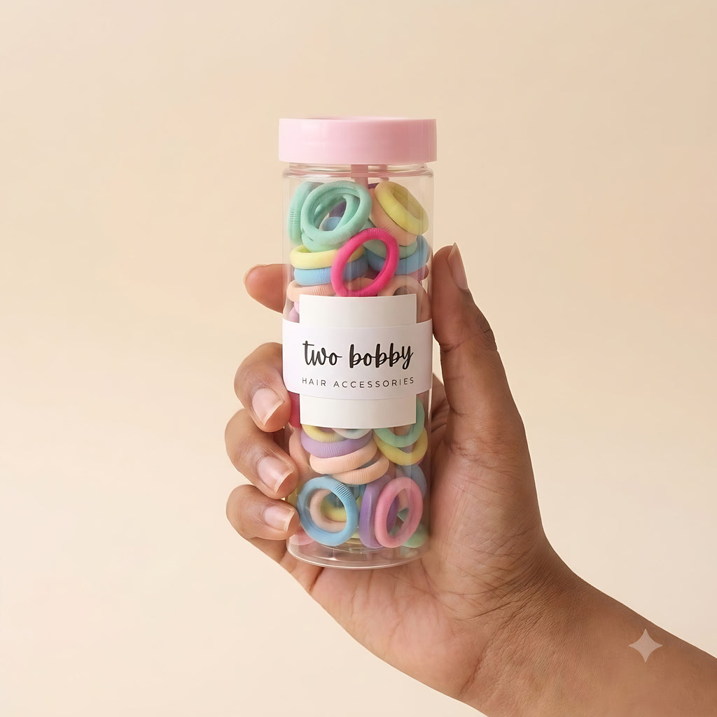 The tube of 100 hair ties held in a hand to show its size