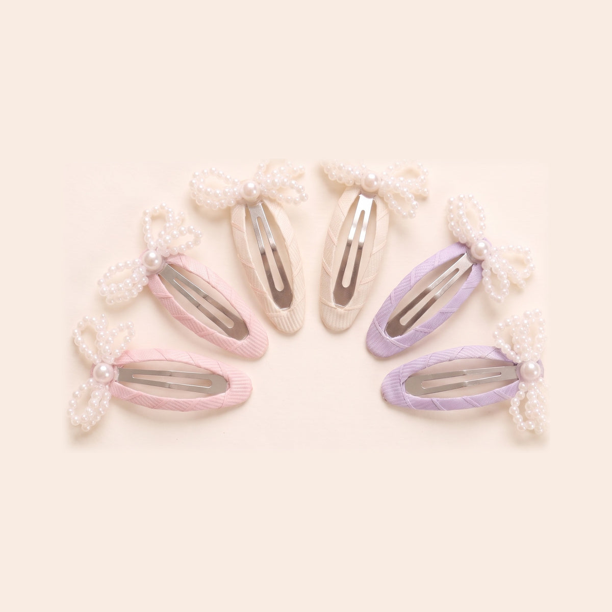 two bobby Mini Pearl Bow Tic Tac Clips - pink, ivory and lavender pairs, close up